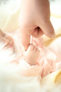 newborn baby hand grasping adult